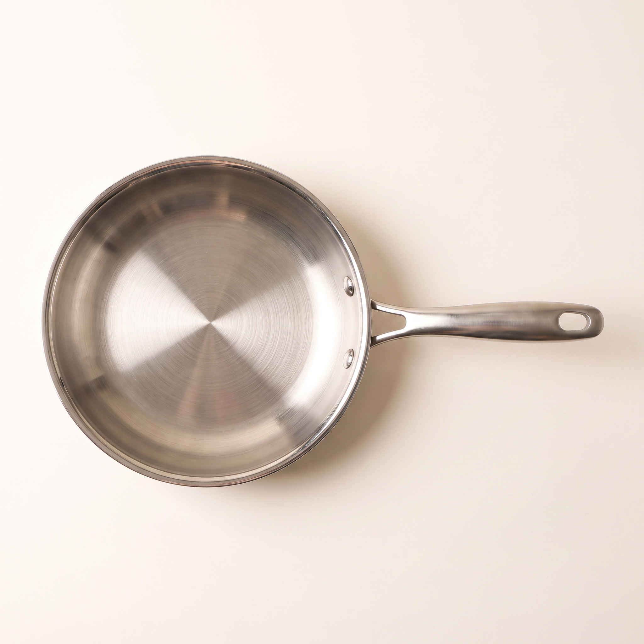 Poêle inox 28 cm vue de dessus, fond entier et trame circulaire