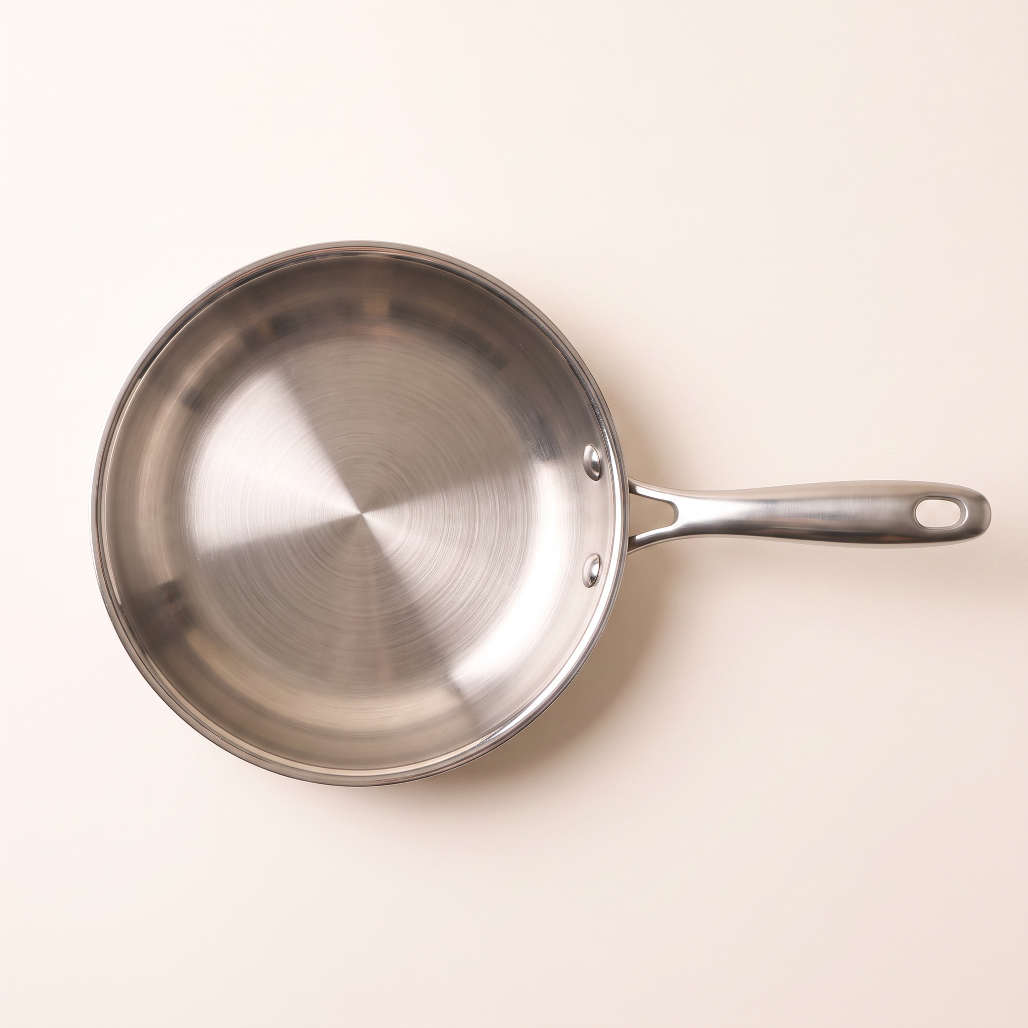 Poêle inox 24 cm vue de dessus, fond entier et trame circulaire