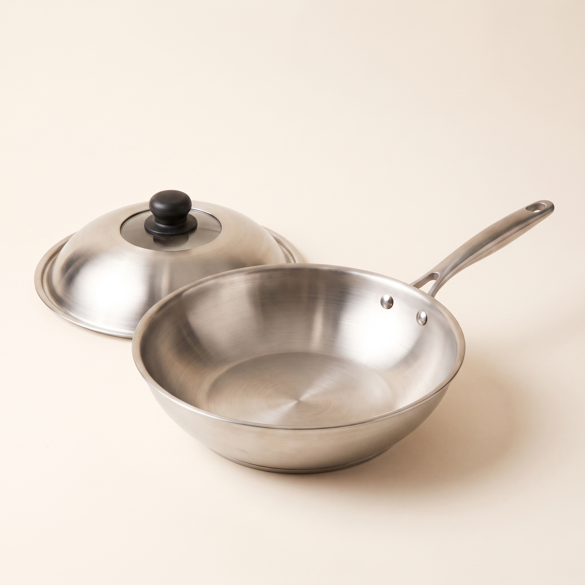 Wok inox 30 cm couvercle posé à côté, intérieur et deux rivets visibles