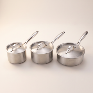 Les trois casseroles Marthe 16, 18 et 20 cm alignées avec leurs couvercles en acier